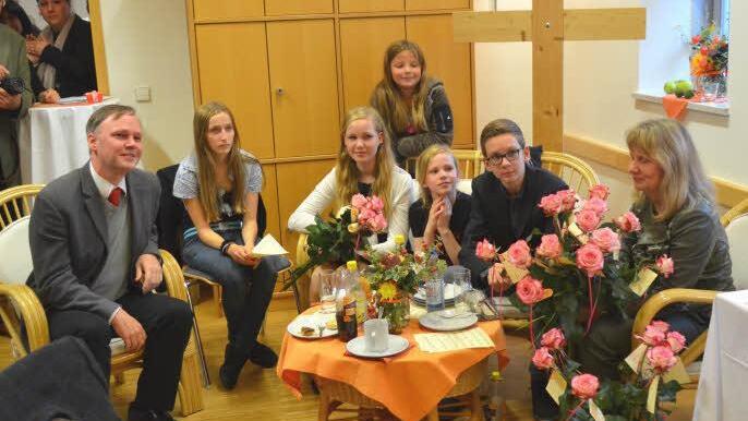 Aufmerksam nimmt Pfarrer Till Roth (links) zusammen mit seiner Familie, Ehefrau Christina, und den Kindern Benedikt, Renate und Katharina (sitzend von rechts) die Grußworte und Beiträge auf. Foto: Thomas Micheel