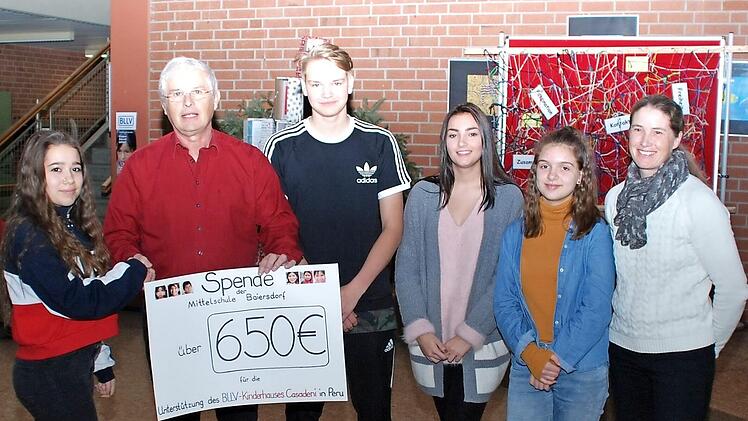 Der Botschafter der Kinderhilfe, Peter Lang, nimmt den Scheck über 650 Euro von den Schulsprechern entgegen. Foto: Susanne Stahl