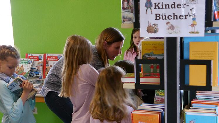 Astrid Wirth hatte die Kindergartenkinder eingeladen und berät sie bei der Buchauswahl. Foto: Oswald Türbl