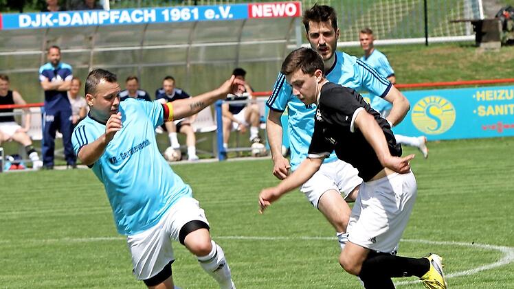 DJK Dampfach - TSV Wiesentheid. Der Wiesentheider Christian Enzbrenner (vorn rechts) im Duell mit dem Dampfacher Paul Tudor; hinten der DJKler Stefan Greb Foto: Günther Geiling