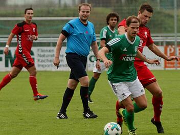 Der Sander  Sebastian Wagner (vorne) behauptet sich gegen seinen Aubstadter Gegenspieler am Ball. Hinten im grünen Trikot Tevin McCullough