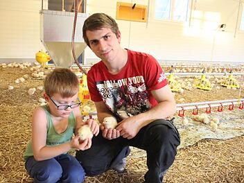 Alexander Hanna und sein sechsjähriger Neffe David im Kükenstall. Die kleinen, flauschigen Babys kriegen Streicheleinheiten.  Fotos: Friedwald Schedel
