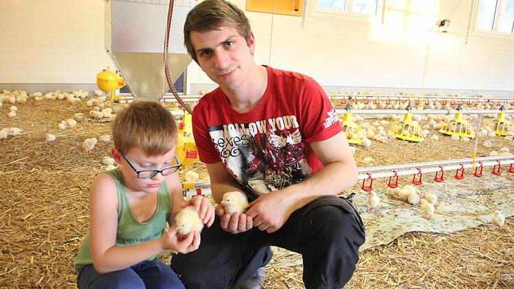 Alexander Hanna und sein sechsjähriger Neffe David im Kükenstall. Die kleinen, flauschigen Babys kriegen Streicheleinheiten.  Fotos: Friedwald Schedel