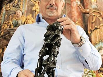 Christian Pohl mit einem ostafrikanischen Lebensbaum aus Ebenholz. Dieser symbolisiere das Miteinander in einer Gemeinde, so der Pfarrer. Foto: Alexander Hartmann