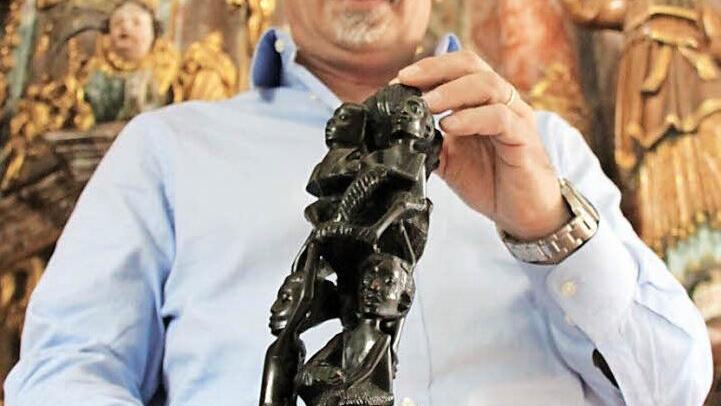 Christian Pohl mit einem ostafrikanischen Lebensbaum aus Ebenholz. Dieser symbolisiere das Miteinander in einer Gemeinde, so der Pfarrer. Foto: Alexander Hartmann