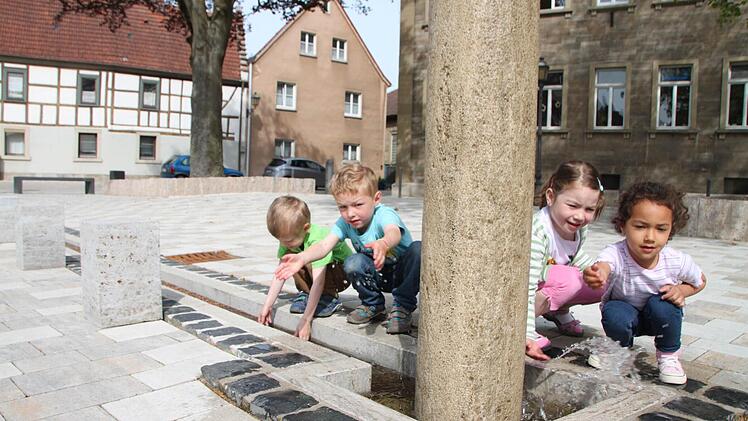 Leon, Niklas, Jule und Alya spielen am neuen Brunnen. Foto: Heike Beudert