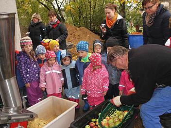 Nach dem Pflücken und Auflesen wurden die Äpfel gewaschen und zur Verkleinerung in den Schredder gegeben. Kirchlauters Altbürgermeister Peter Kirchner (rechts) und Kindergartenleiterin Alexandra Geuß (dahinter) mit den Erzieherinnen. Foto: Günther Geiling