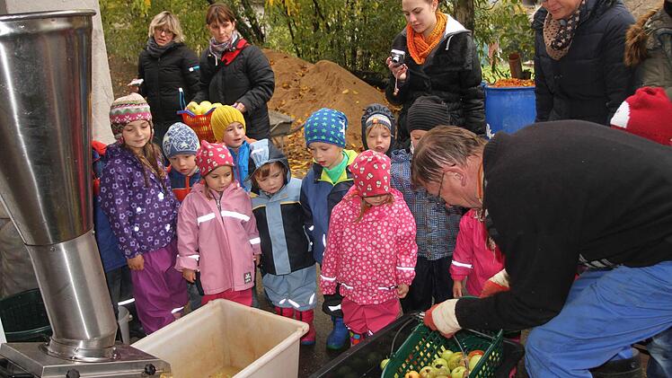 Nach dem Pflücken und Auflesen wurden die Äpfel gewaschen und zur Verkleinerung in den Schredder gegeben. Kirchlauters Altbürgermeister Peter Kirchner (rechts) und Kindergartenleiterin Alexandra Geuß (dahinter) mit den Erzieherinnen. Foto: Günther Geiling