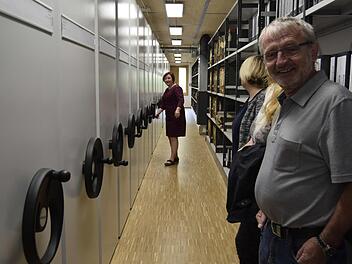 Geschäftsleiterin Sigrid Lang betätigt die Rollschrankanlage. Ulrich Sünkel (rechts) und Christine Wittenbauer staunen über die Leichtgängigkeit der schweren Schränke. Fotos: Andreas Welz