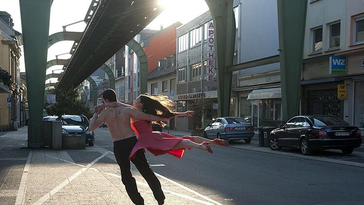Fabien Prioville und Azusa Seyama tanzen unter der Wuppertaler Schwebebahn.