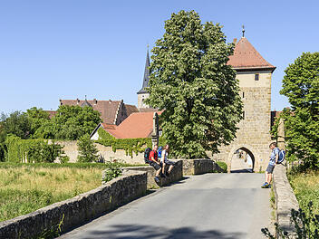 Wanderer vor der alten Sesslacher Stadtmauer.
