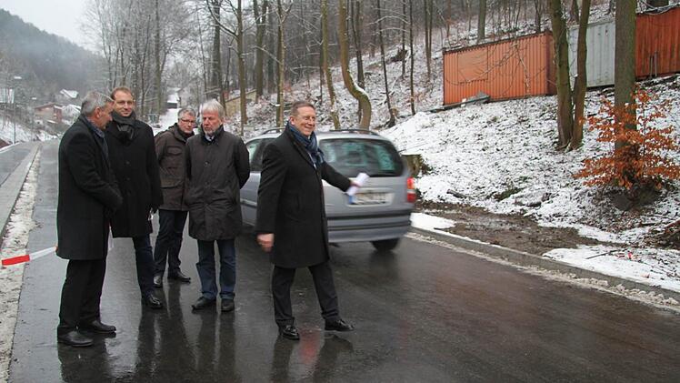 Während Stephan Pröschold von den Stadtwerken, Ingo Wolfgramm von der Stadt Kulmbach, Steffen Groschupp und Claus-Lutz Schreyer von der Günther-Bau (von links) noch das von Oberbürgermeister Henry Schramm durchschnittene Band halten, rollt der Verkehr schon wieder durch die Wolfskehle. Foto: Sonja AdamWolfskehleeröffnung