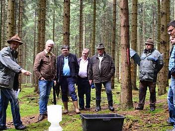 Förster Peter Schwarzmeier (links) führte in einem Versuch die Leistungsfähigkeit eines gemischten Waldes gegenüber nicht bewirtschafteten vor. Aufmerksame Beobachter sind unter anderem, ab 2. von links, Bürgermeister Timo Ehrhardt (Ludwigsstadt), Bürgermeister Peter Klinger (Tschirn), auch Vorsitzender der WBV Frankenwald und Georg Konrad (Vorsitzender WBV Kronach-Rothenkirchen). Foto: K.- H. Hofmann