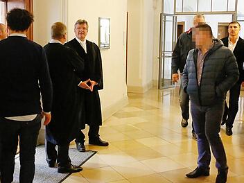 Box-Champion Marco Huck (ganz rechts) nähert sich mit zwei Begleitern dem Verhandlungssaal im Bamberger Landgericht. Foto: Matthias Hoch