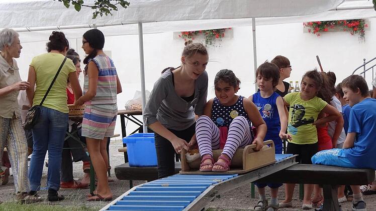 Hopp, rauf auf die Rollenrutsche! Beim Sommerfest der Caritas helfen Caritas-Mitarbeiter und Ehrenamtliche bei der Kinderbetreuung mit.