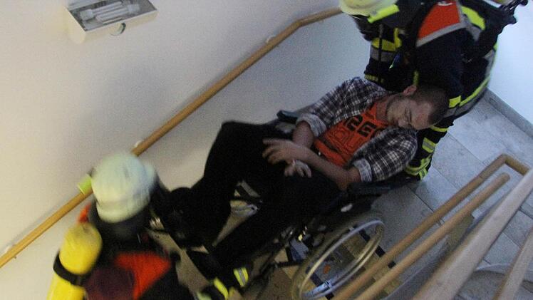 Keine einfache Sache: Die Bergung eines Rollstuhlfahrers und dessen Transport durch das Treppenhaus. Doch die Rettungskräfte meisterten bei der Großübung im Stadtsteinacher Seniorenheim auch diese Aufgabe mit Bravour. Foto: Sonja Adam