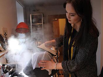 Sandra Ullmann in ihrer Werkstatt: Mit dem Bügeleisen bearbeitet sie den Wollfilz und gibt ihm die richtige Form. Foto: Ulrike Müller