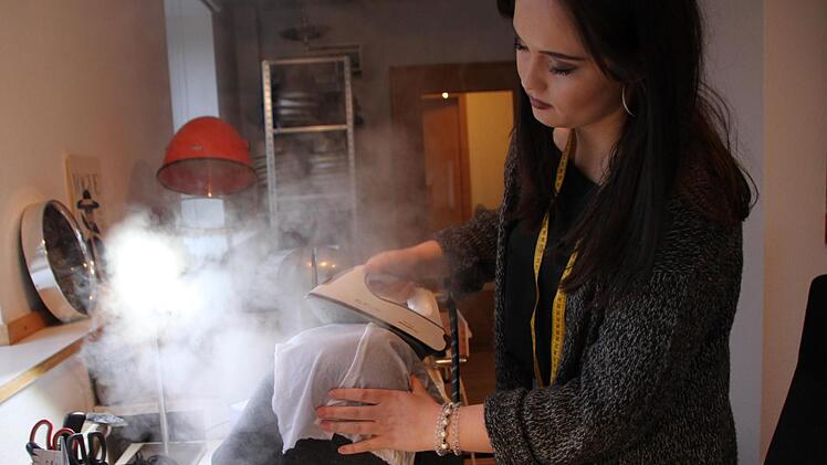 Sandra Ullmann in ihrer Werkstatt: Mit dem Bügeleisen bearbeitet sie den Wollfilz und gibt ihm die richtige Form. Foto: Ulrike Müller