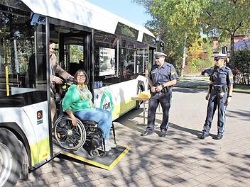 Mit Rollstuhl in den Bus: Regina Guthberlet vom Seniorenbeirat in Adelsdorf testet - Busfahrer Christian geht zur Hand. Die Verkehrserzieher der Polizei Höchstadt - Michaela Rosenthal und Bernd Bayer beobachten das Ganze