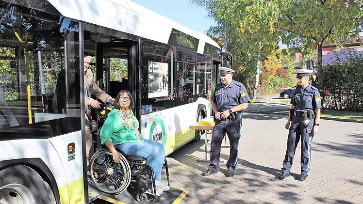 Mit Rollstuhl in den Bus: Regina Guthberlet vom Seniorenbeirat in Adelsdorf testet - Busfahrer Christian geht zur Hand. Die Verkehrserzieher der Polizei Höchstadt - Michaela Rosenthal und Bernd Bayer beobachten das Ganze