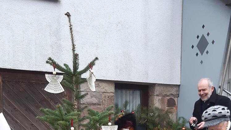 Die Geschwister Helena und Rosalie Gerr aus Singenrain  verkaufen die selbstgebastelten Weihnachtsengel gegen eine freiwillige  Spende.  Pfarrer Armin Haas (hinten, rechts) freut sich über diese Aktion.   Foto: Isabell Gerr