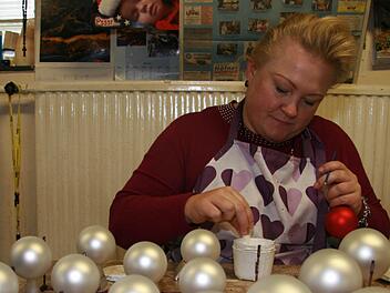 Mit Kleber malt Silke Eckardt (36) einen Elch auf die Kugeln und bestäubt diesen dann mit Glitter: Das ist die festliche Variante skandinavischer Weihnacht - natürlich auch in Weiß-Rot oder Frost-Rot. Fotos: Sonja Adam