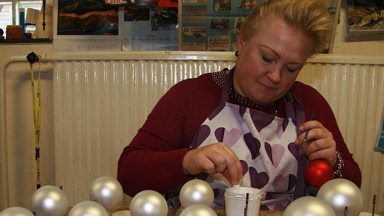 Mit Kleber malt Silke Eckardt (36) einen Elch auf die Kugeln und bestäubt diesen dann mit Glitter: Das ist die festliche Variante skandinavischer Weihnacht - natürlich auch in Weiß-Rot oder Frost-Rot. Fotos: Sonja Adam