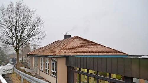 Die Mittelschule Bad Bocklet wurde 1964 als Volksschule errichtet und zehn Jahre später um eine Turnhalle erweitert. Die letzte große Sanierung und Umplanung fand 1994 statt. Inzwischen ist nicht nur eine energetische Sanierung notwendig, sondern eine Generalsanierung. Derzeit befindet sich ein Bauzaun vor dem Schulhaus, weil der Hang stabilisiert wird. Foto: Kathrin Kupka-Hahn