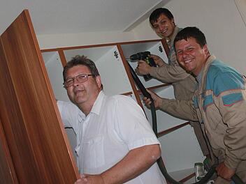 Teamwork gefragt: Willi Unglaub, Christoph Schwämmer und Alexander Braun (von links) sind mit dem Aufbau des Kleiderschranks beschäftigt.   Fotos: Sabine Herteux