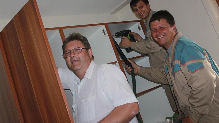 Teamwork gefragt: Willi Unglaub, Christoph Schwämmer und Alexander Braun (von links) sind mit dem Aufbau des Kleiderschranks beschäftigt.   Fotos: Sabine Herteux
