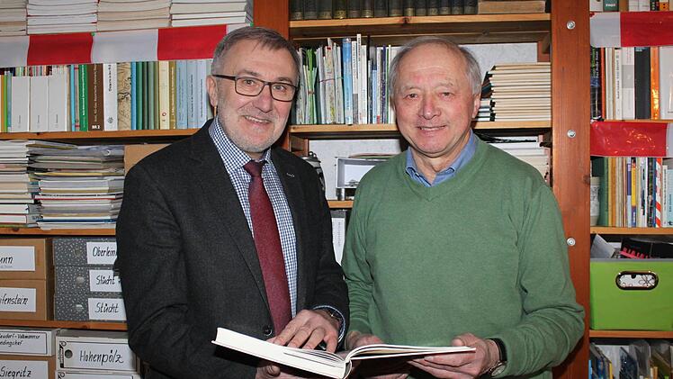 Helmut Krämer und Hans Dorsch schmökern in der Heiligenstädter Chronik. Foto: Carmen Schwind