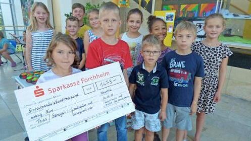 Den Spendenscheck halten Aurelia Heidermann und Julius Distler