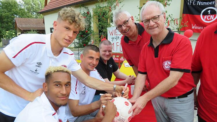 Signieren für einen guten Zweck: Ottmar Kerner (rechts) hatte einen Ball aus den 90er Jahren mitgebracht, der von den Gästen signiert wurde. Der Ball soll für einen sozialen Zweck gespendet werden. Foto: Monika Schütz
