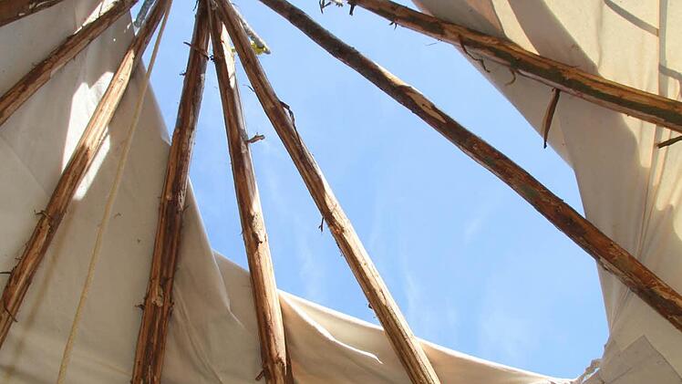 Basis des Tipis sind lange Holzstangen und ein Baumwolldeck.