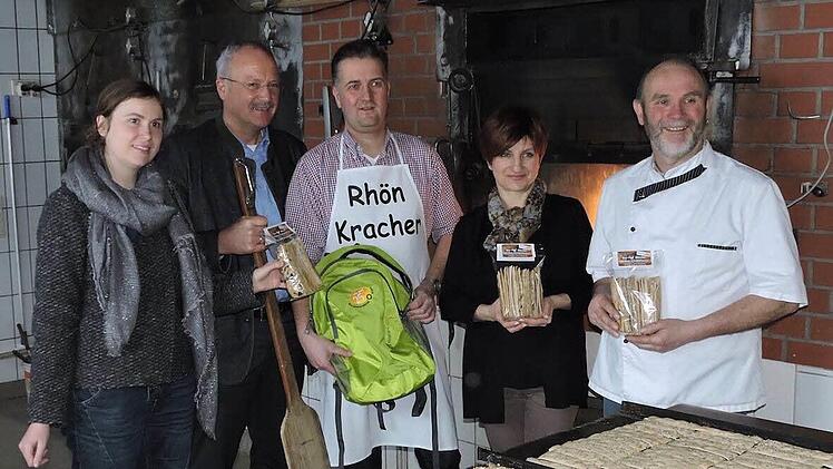 Finden die Cracker lecker (von links): Julia R&ouml;sch (Jubil&auml;umskoordinatorin), Manfred Helfrich, Torsten Raab, Hannelore Rundell (Dachmarke Rh&ouml;n) sowie Bio-B&auml;cker Christof Gensler. Der Rucksack in den H&auml;nden von Torsten Raab wird bei Sonderaktionen im Jubil&auml;umsjahr mit &Uuml;berraschungen gef&uuml;llt und am Ende verlost. Die Rh&ouml;nkracher durften da nicht fehlen. Foto: Biosph&auml;renreservat