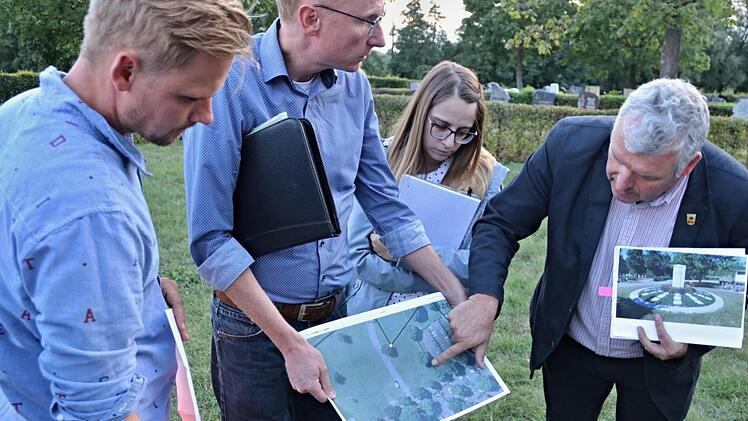 Bürgermeister Jürgen Hennemann (rechts) und Bauamtsleiter Martin Lang (Zweiter von links), erläutern anhand von Plänen die geplanten Urnengräber und die Grabstätte für Muslime. Links steht Bauhofleiter Christian Raehse und die Bauamtsangestellte Michelle Georg war vor Ort.