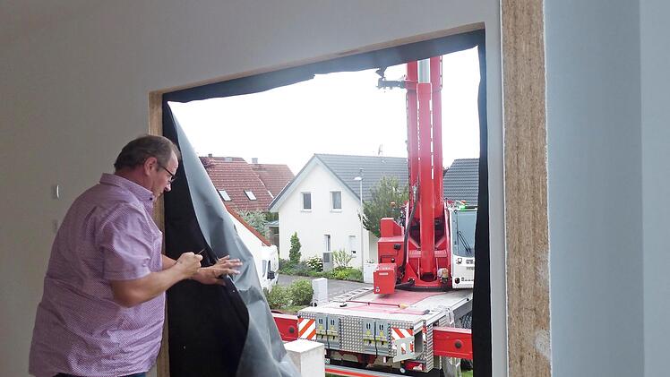 Dieter Balazs entfernt eine Plane im ersten Modul, an das das zweite Modul angefügt wird. Dahinter ist der 200-Tonnen-Kran zu sehen.