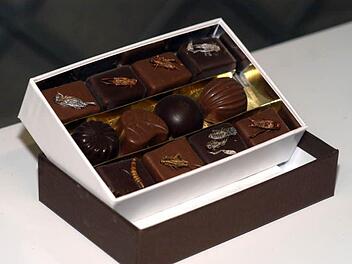 Manch einer gönnt sich sogar freiwillig den Genuss von Insekten: Eine Box mit Schokopralinen, die vom französischen Chocolatier Guy Roux mit Grillen und Mehlwürmern dekoriert wurden, Foto: dpa