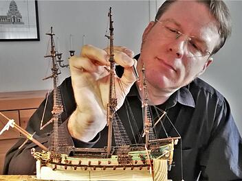 Buddelschiffbauer Matthias Schultz (49) bei der Arbeit am maßstabsgetreuen Nachbau der "Wappen von Bremen" aus dem Jahr 1689. Foto: Sigismund von Dobschütz