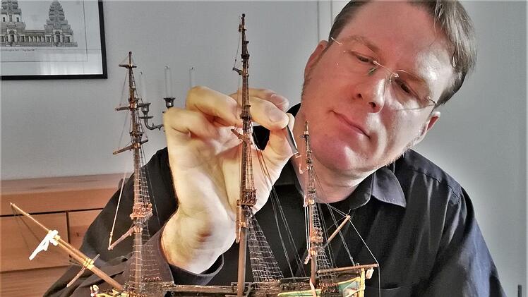 Buddelschiffbauer Matthias Schultz (49) bei der Arbeit am maßstabsgetreuen Nachbau der "Wappen von Bremen" aus dem Jahr 1689. Foto: Sigismund von Dobschütz
