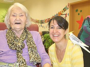 Else Ernst fühlt sich in der Tagespflege des Roten Kreuzes am Steingraben sichtlich wohl. Dazu tragen unter anderem Teamleiterin Beate Schmitt und Nymphensittich "Elvis" bei. Foto: Ralf Ruppert