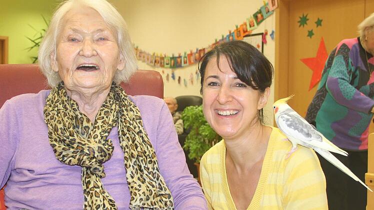 Else Ernst fühlt sich in der Tagespflege des Roten Kreuzes am Steingraben sichtlich wohl. Dazu tragen unter anderem Teamleiterin Beate Schmitt und Nymphensittich "Elvis" bei. Foto: Ralf Ruppert