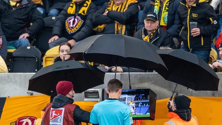 Bemüht der Schiedsrichter den Videobeweis - wie hier jüngst Benjamin Cortus im Rudolf-Harbig-Stadion beim 1:1 zwischen Dresden und Sandhausen in der 2. Liga, dann verhagelt diese Maßnahme oft die Stimmung von Spielern und Zuschauern. Foto: Robert Michael/dpa