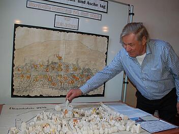 Horst Gundel stellt im Modell zum Stadtbrand den Kirchtum an die Stelle, an die er gehört. Fotos: Rainer Lutz