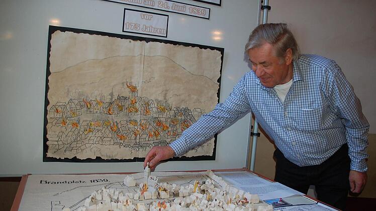 Horst Gundel stellt im Modell zum Stadtbrand den Kirchtum an die Stelle, an die er gehört. Fotos: Rainer Lutz