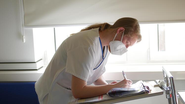 Eine Schwesternsch&uuml;lerin dokumentiert konzentriert die Werte ihres Patienten. Ein Fehler k&ouml;nnte verheerende Folgen haben.