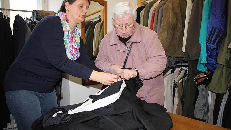 Erika Ankenbrand unterstützt Stammkundin Christa Raducan, die schon seit vielen Jahren ins Kramlädchen der Caritas in Bad Brückenau kommt. Foto: Ulrike Müller