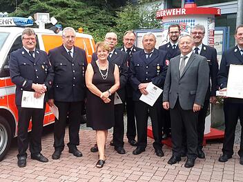 Gruppenbild mit Dame: Gerhard Knüttel (von links), Gerhard Seitner, Hubert Breitenbach, Bürgermeisterin Brigitte Meyerdierks, Kreisbrandrat Benno Metz, Winfried Uebelacker, Christian Kötzner, Landrat Thomas Bold, Kreisbrandinspektor Marco Brust und Michael Krug. Foto: Rolf Pralle
