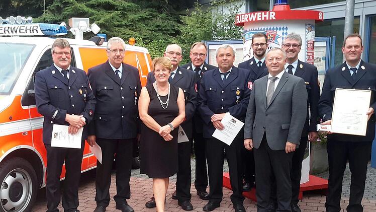 Gruppenbild mit Dame: Gerhard Knüttel (von links), Gerhard Seitner, Hubert Breitenbach, Bürgermeisterin Brigitte Meyerdierks, Kreisbrandrat Benno Metz, Winfried Uebelacker, Christian Kötzner, Landrat Thomas Bold, Kreisbrandinspektor Marco Brust und Michael Krug. Foto: Rolf Pralle