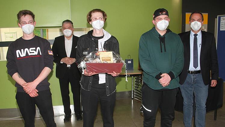 Damien Roksela, Kevin Dressendörfer und Hannes Nowak haben - gemeinsam mit Hannah Schmitt (nicht im Bild)  - eine Zitronenbratwurst entwickelt. Mit im Bild Landrat Klaus Peter Söllner und Schulleiter  Alexander Battistella (rechts).